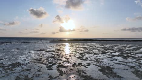 reflexiones del amanecer en las llanuras de marea durante la marea baja en la playa de filipinas