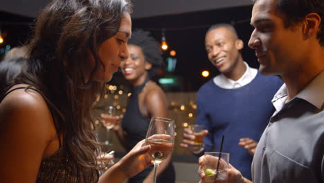 couples dancing and drinking at evening party, slow motion