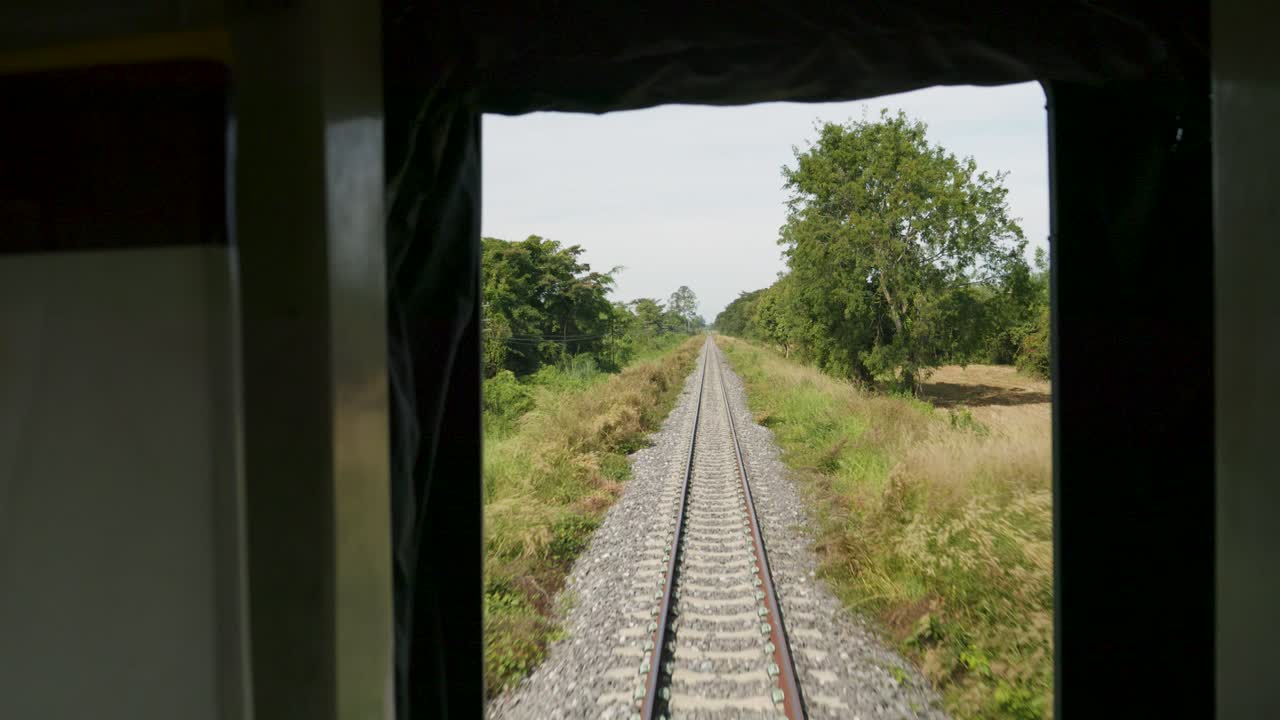 POV shot from train of Thailand's Eastern Line from Bangkok to Ban Klong Luk during the day in Thailand, medium shot