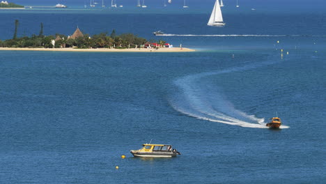 Water-taxi-carries-tourists-between-Anse-Vata-Beach-and-Duck-Island,-New-Caledonia