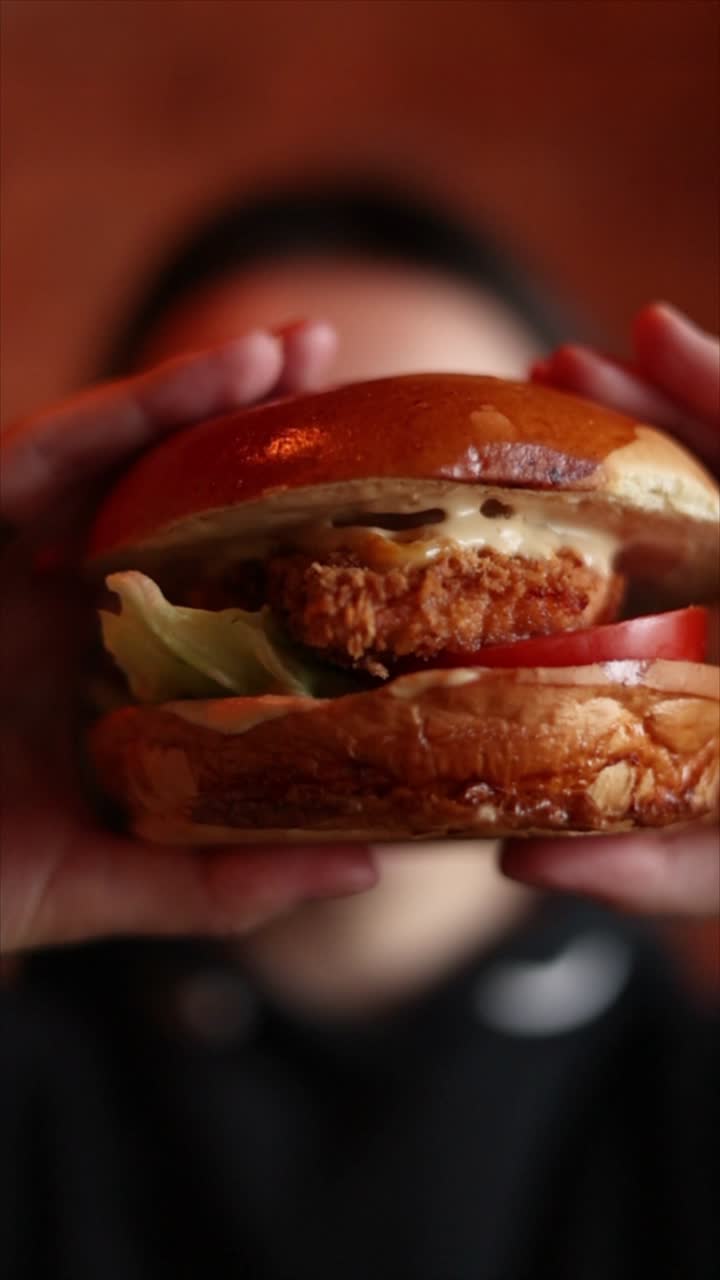 una persona sosteniendo un delicioso sándwich de pollo