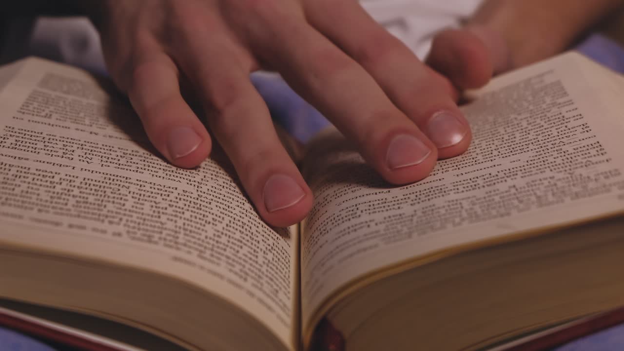 CHISINAU, MOLDOVA - APRIL 25, 2020: Caucasian man reading a book at the evening. Close up
