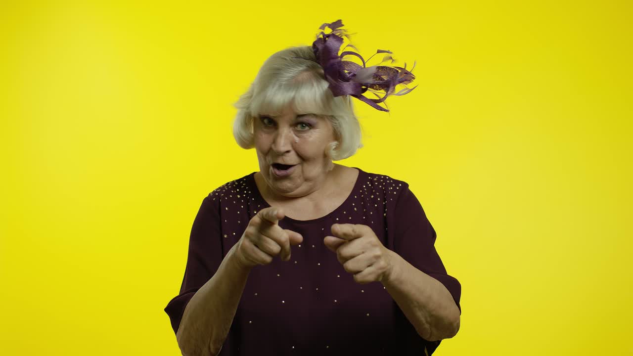 Excited senior old woman pointing herself, looking around and bragging about own success, winning