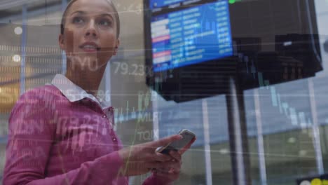 Animation-of-financial-data-processing-over-caucasian-businesswoman-using-smartphone-at-the-airport