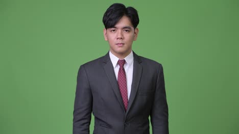 joven y guapo hombre de negocios asiático señalando con el dedo