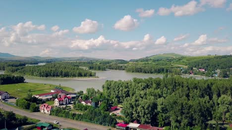 Aerial-shot-Top-view-of-the-tourist-city-mountains-pine-and-deciduous-forest-mountain-river-3-Under-the-clouds