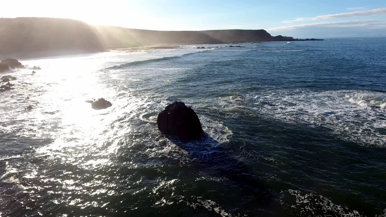 햇빛에 반짝이는 파도 위로 섬 절벽 가장자리를 따라 향하는 조감도