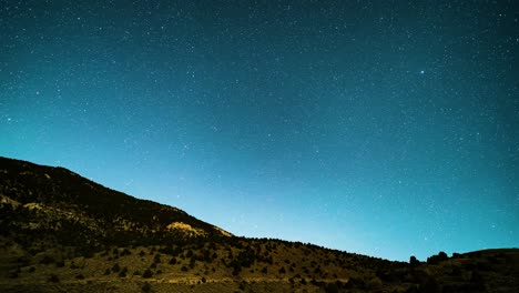 As-the-moon-sets-and-shadows-darken-the-land,-the-Milky-Way-core-rises-in-this-dramatic-nightscape-time-lapse