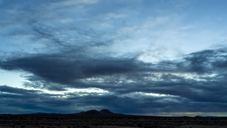 desierto de mojave en una noche nublada con el amanecer trayendo un amanecer colorido - lapso de tiempo estático de gran angular