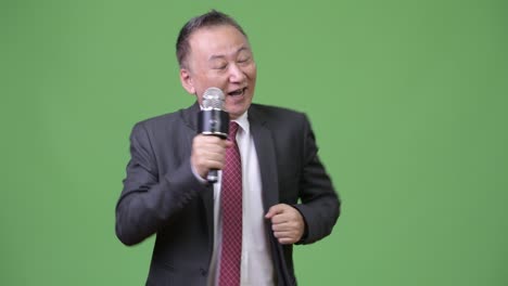 mature japanese businessman using microphone