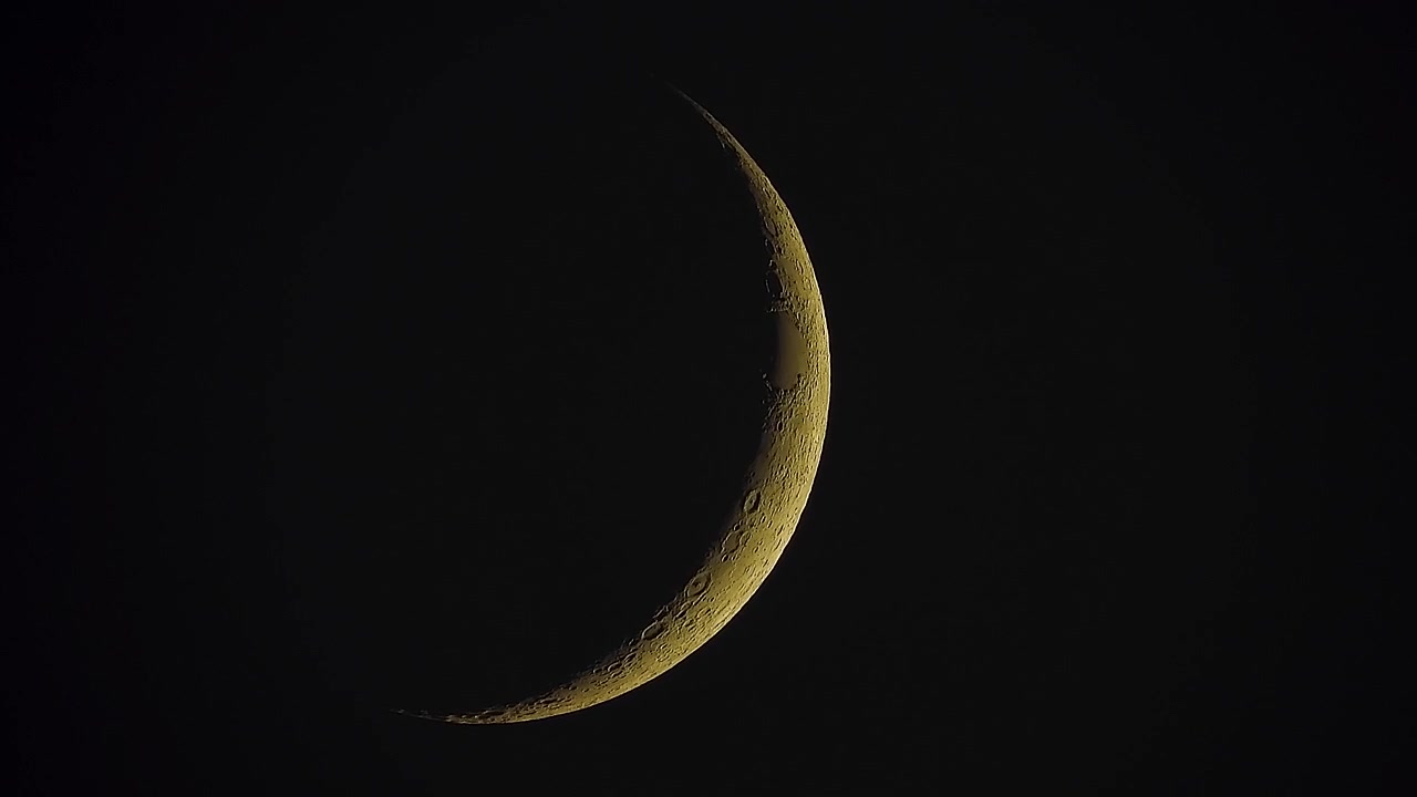 Lua crescente brilhando no céu noturno escuro.
