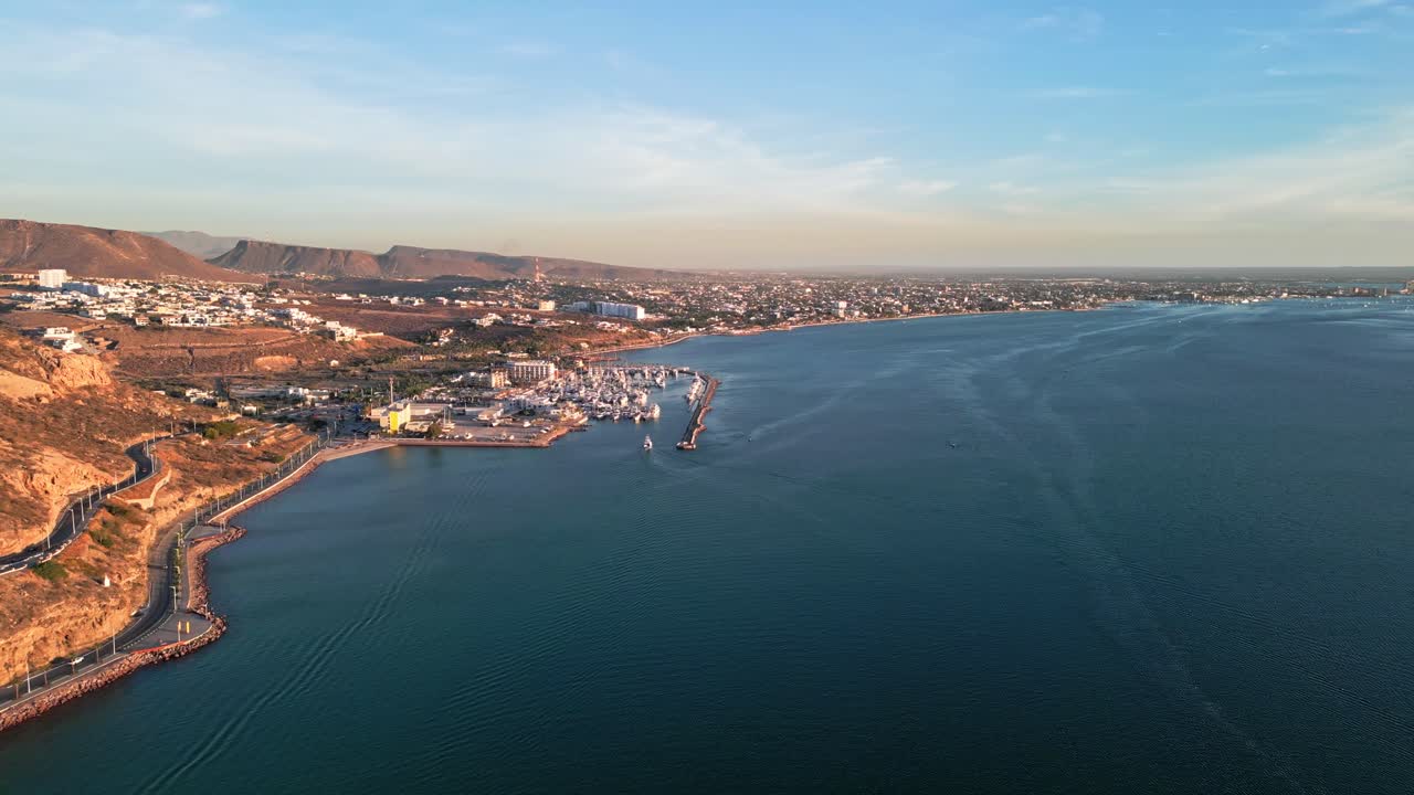 Golden sunset over La Paz coast, Malecon Calavera, with harbor and distant cityscape