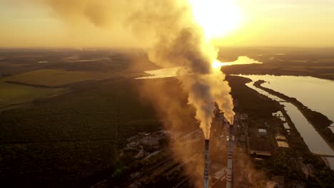 industrial zone with pipes among nature. thick white smoke is poured from the factory pipe at sunset. pollution of the environment. ecological problems. aerial view