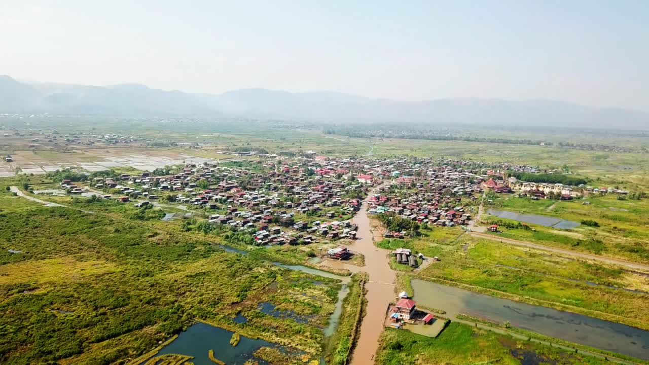 ofrece una vista aérea de casas únicas sobre pilotes, intrincados sistemas de canales y paisajes exuberantes alrededor del lago inle en myanmar, revelando la rica cultura y la belleza natural de la región.