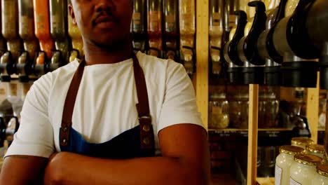 male staff standing with arms crossed in supermarket 4k