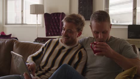 Caucasian-male-couple-in-social-distancing-in-their-sofa-at-home