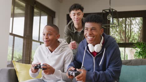 happy diverse male teenage friends playing video games at home, slow motion