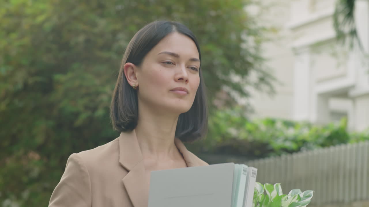 Unemployed Businesswoman Walking with Office Stuff along Street