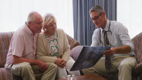 senior couple talking with a doctor in retirement house