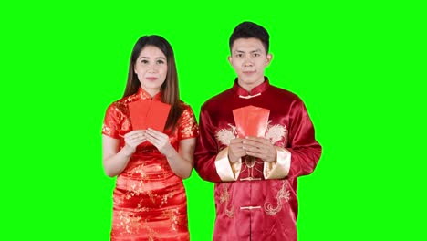 asian couple holding red envelope in studio