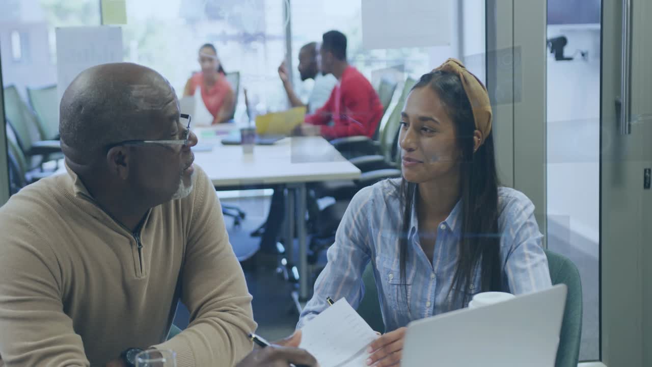 Senior mentor pointing at documents, woman annotating in education, transparent overlays appearing