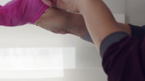 profesional médico poniéndose guantes de látex - cerrar las manos de la mujer