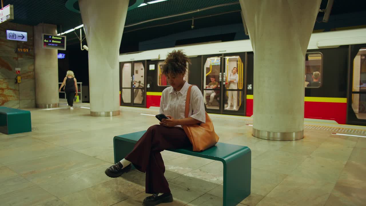Donna che aspetta il treno nella stazione della metropolitana