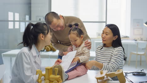 asian family with toddler daughter visiting pediatrician