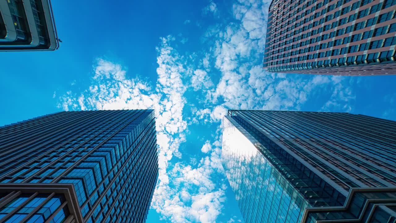 un lapso de tiempo de la nube que refleja el edificio en la ciudad de negocios amplia toma
