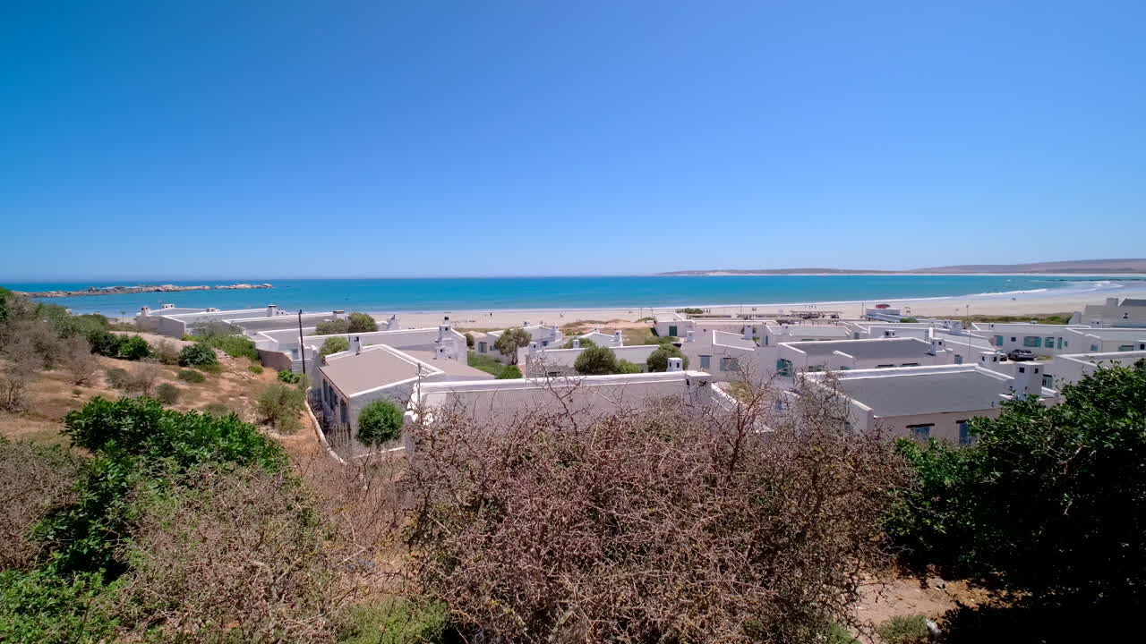 Vista panoramica sulle case imbiancate a calce verso la spiaggia e l'oceano a Paternoster