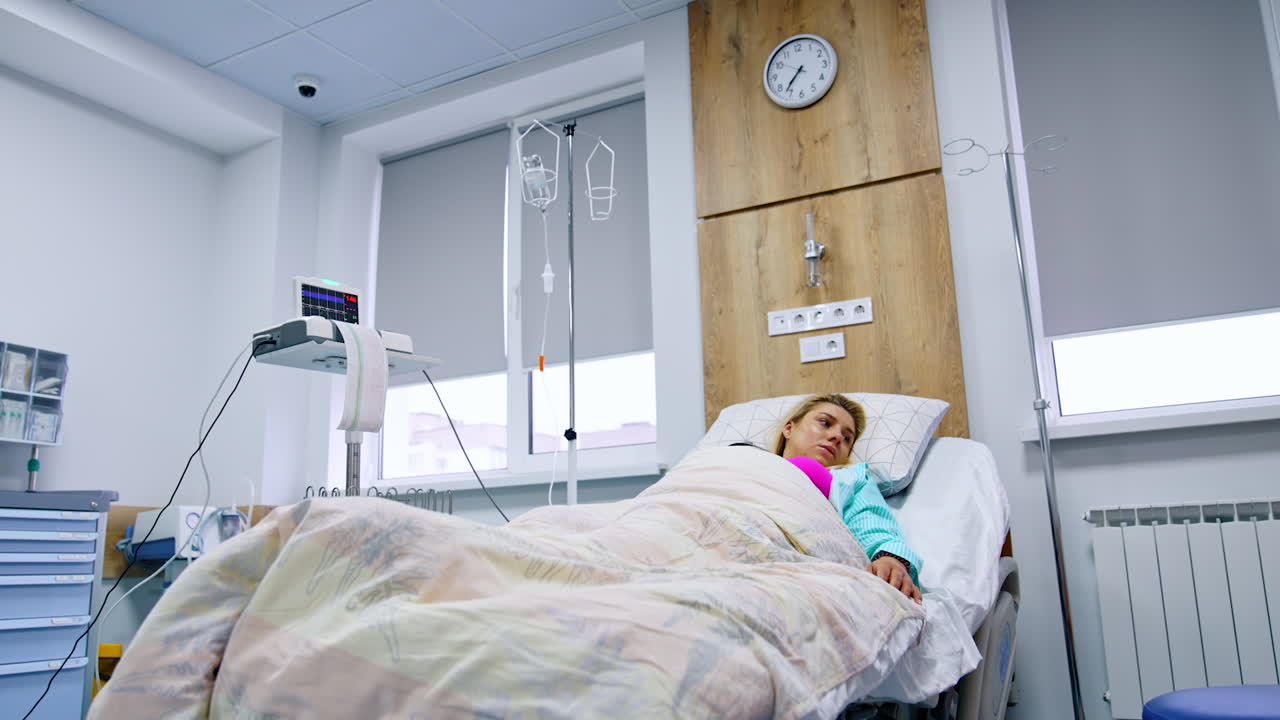 Pregnant woman having examination on cardiograph. Caucasian lady is having electrocardiogram. Low angle view.