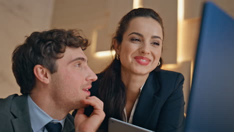positive office couple discussing task working together at computer closeup.