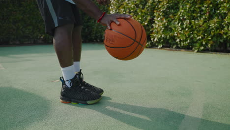 hombre sosteniendo baloncesto en la cancha al aire libre