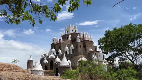 Tilting-up-wide-shot-of-the-large-incredible-Castle-"Zé-dos-Montes"-built-by-Jose-by-hand-with-bricks-from-instructions-by-God-in-Rio-Grande-do-Norte,-Brazil-on-a-warm-sunny-cloudy-day