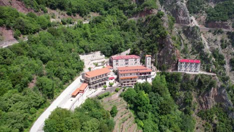 prusos monastery in evrytania, greece – aerial view of historic cliffside monastery surrounded by forest and mountains in central greece