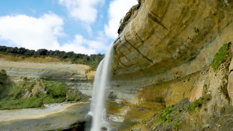 Cinematic-shot-of-floating-Magatiti-Falls-down-the-rocky-cliff-in-reserve-area-of-New-Zealand