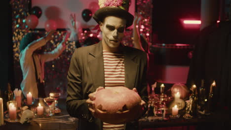 young man holding a pumpkin.