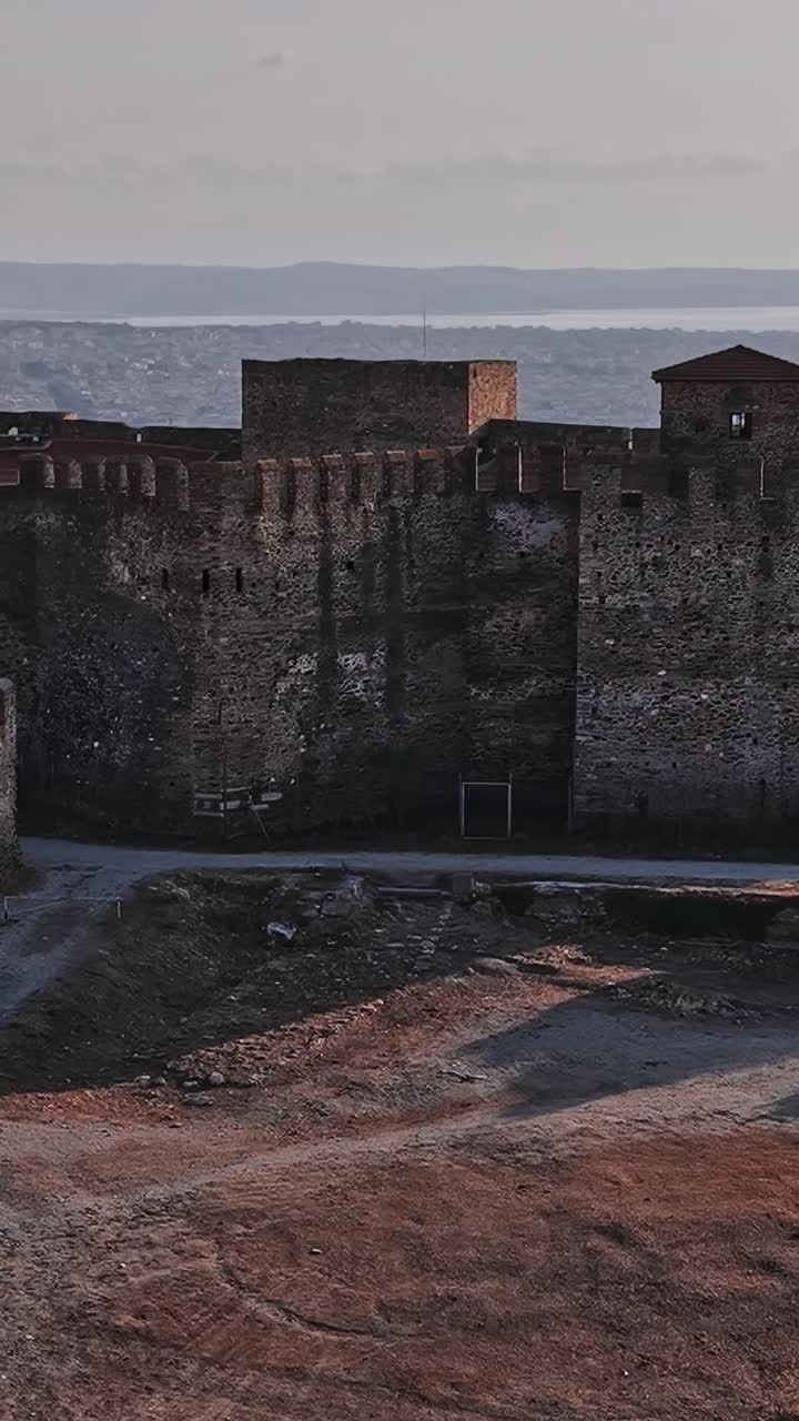 Un castello storico domina la costa della Grecia al tramonto.