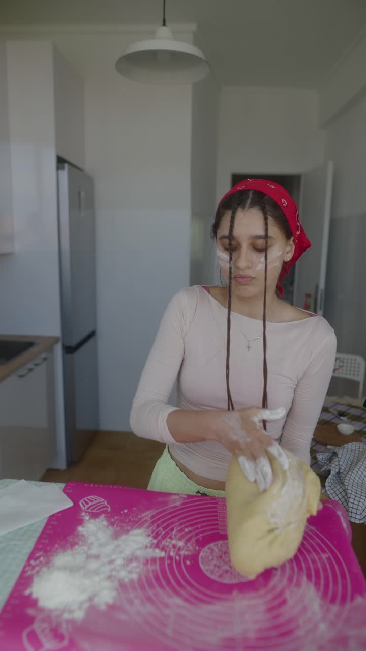 Teenage Girl Kneading Dough in Kitchen