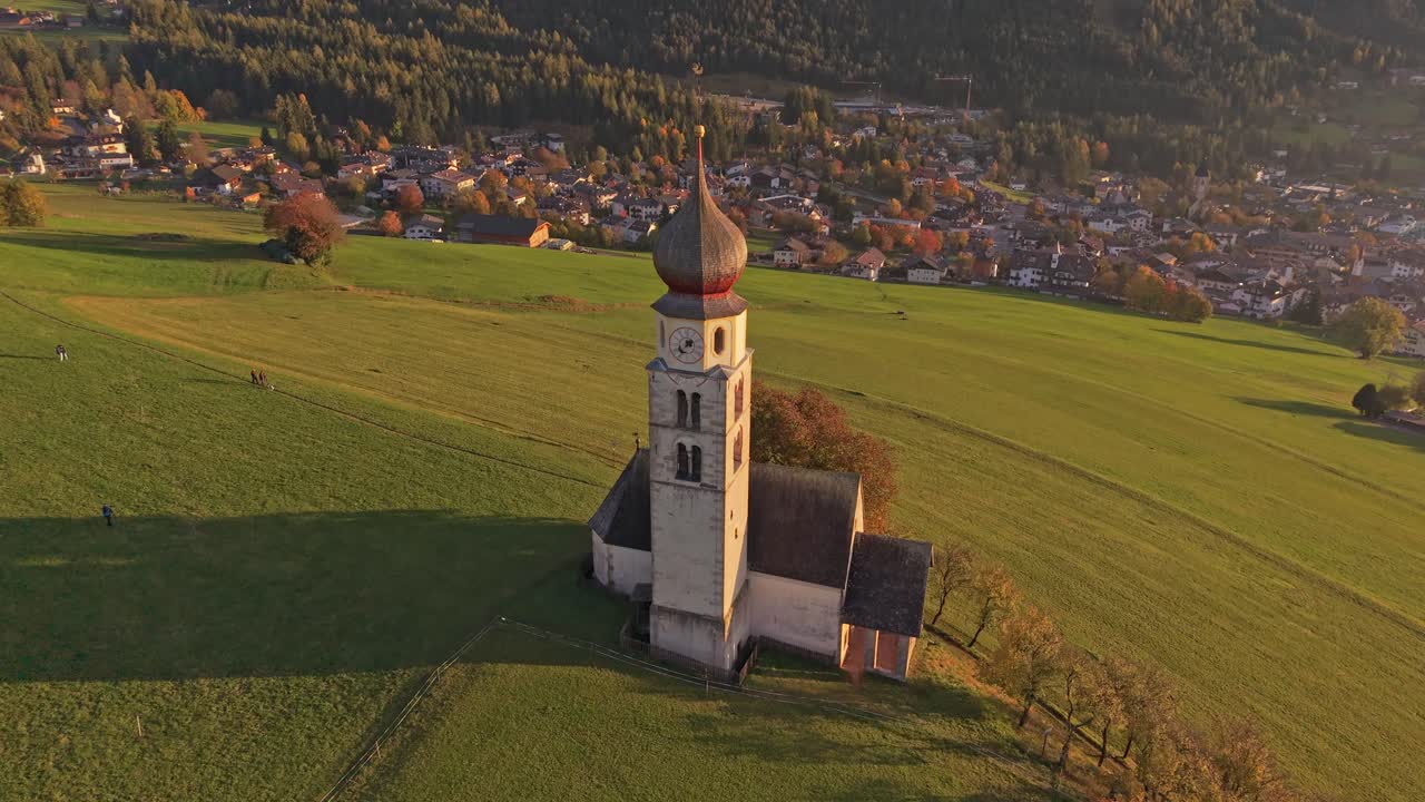 Majestätische Kirche San Valentino und Berggipfel, von einer Drohne aus gesehen, Italien.