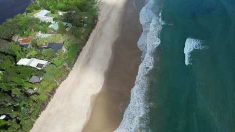 aerial view over sandy shore of belongil beach in byron bay, nsw, australia - drone shot