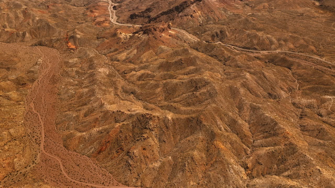 Lifeless deserted rocky landscape with no vegetation. Drone footage above the Mojave desert at daytime.