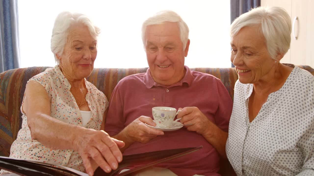 행복 한 고위 친구 들 이 사진 앨범 을 보고 있다