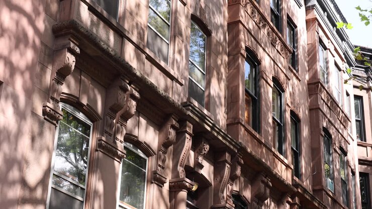 Ripresa dal basso verso l'alto di una casa a schiera in brownstone a Brooklyn con la bandiera degli Stati Uniti