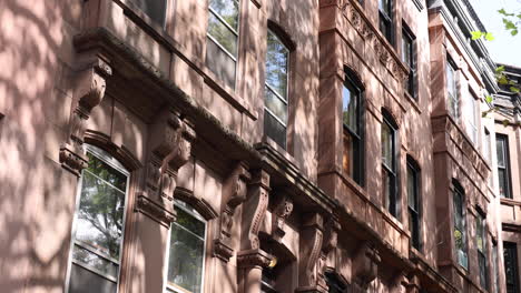 tilt-up view of brownstone redbrick townhouse in brooklyn with usa flag