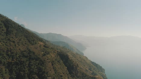 Antena-De-Drones-Volando-Sobre-Las-Montañas-Que-Rodean-El-Lago-De-Atitlán,-Guatemala-Durante-Una-Mañana-Nublada