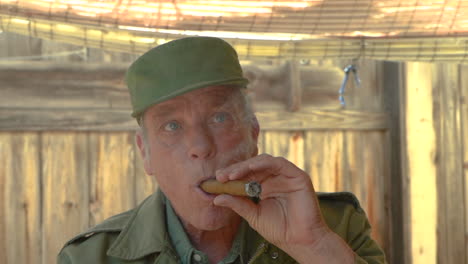 apuesto anciano fumando un cigarro, cámara acercándose