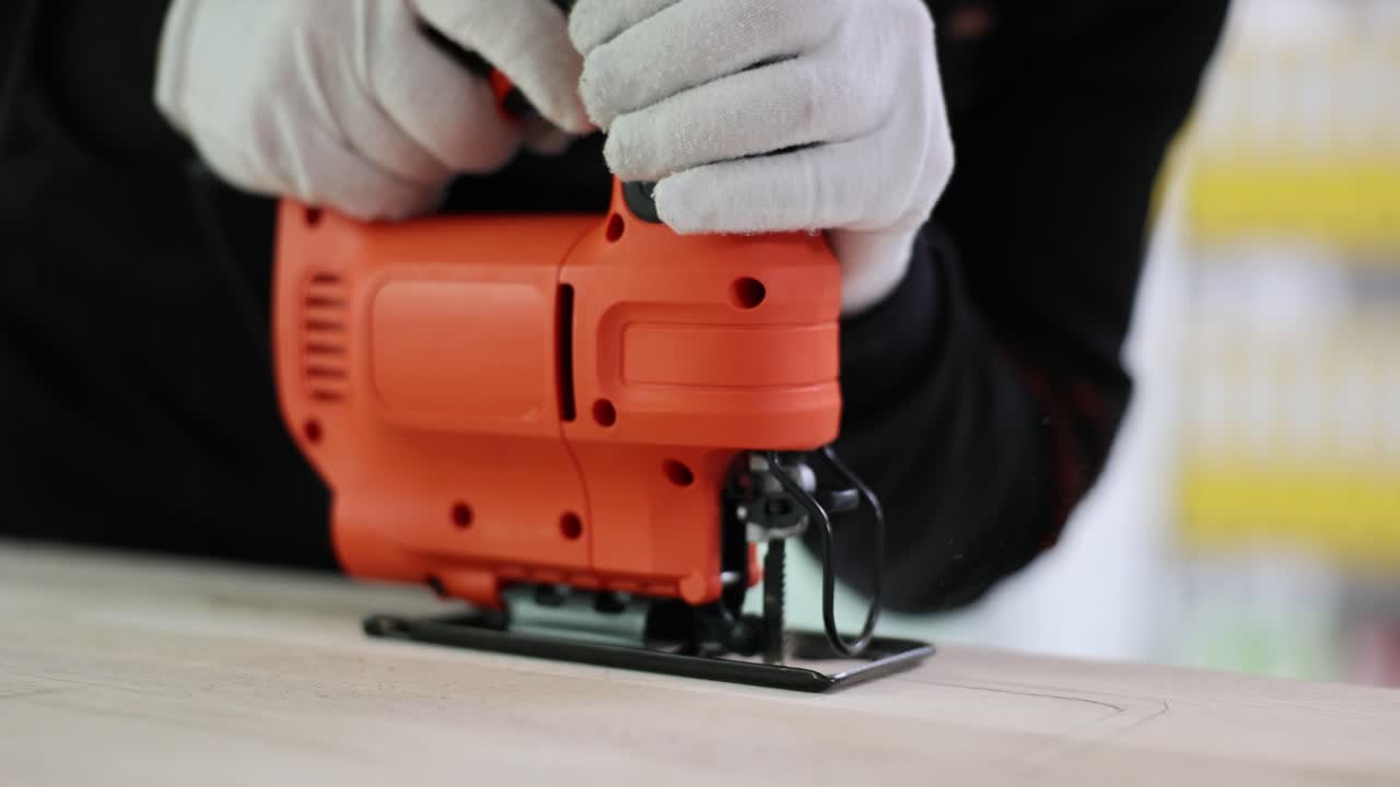 Close-up of hands operating a jigsaw