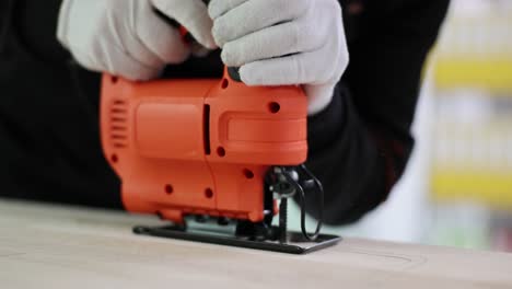 close-up of hands operating a jigsaw