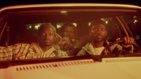 amigos negros posando en un coche iluminado por luces de policía parpadeantes por la noche
